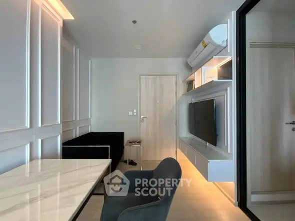 Modern living room with sleek furniture and wall-mounted TV in a stylish apartment.