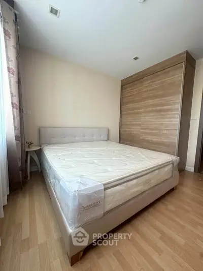 Spacious bedroom with elegant wooden wardrobe and comfortable bed in modern apartment.