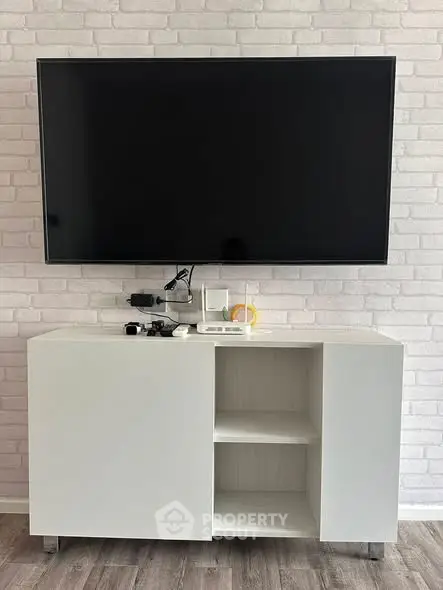 Modern living room with sleek TV setup and stylish white cabinet