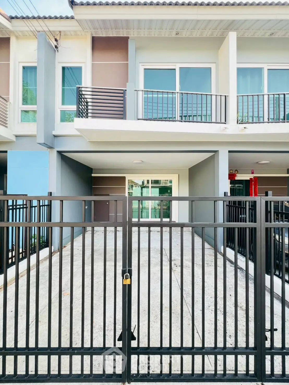 Modern townhouse exterior with gated driveway and balcony