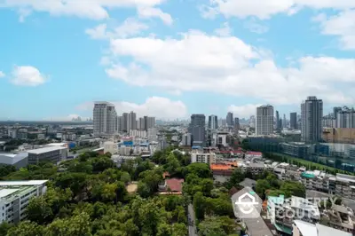 Stunning cityscape view with lush greenery and modern skyscrapers under a bright blue sky.