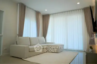 Spacious living room with elegant curtains and cozy sofa in modern apartment.