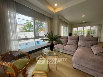 Spacious living room with modern furniture and pool view, perfect for relaxation.