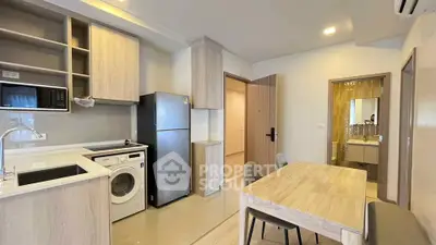 Modern kitchen with washing machine and dining area in sleek apartment