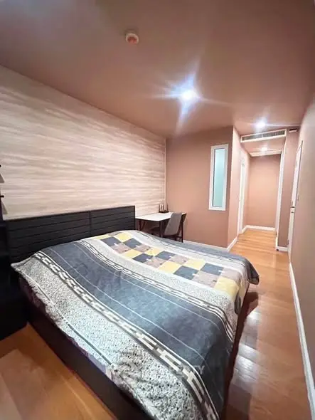 Cozy bedroom with modern decor and wooden flooring, perfect for relaxation and comfort.