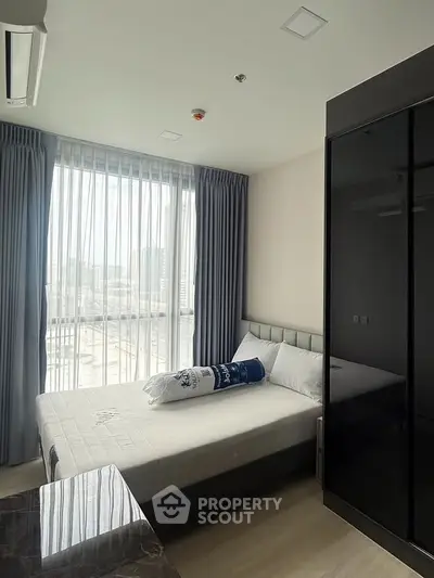 Modern bedroom with large window and stylish decor in urban apartment
