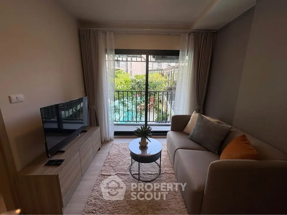 Cozy living room with garden view, featuring modern sofa and flat-screen TV, perfect for relaxation.