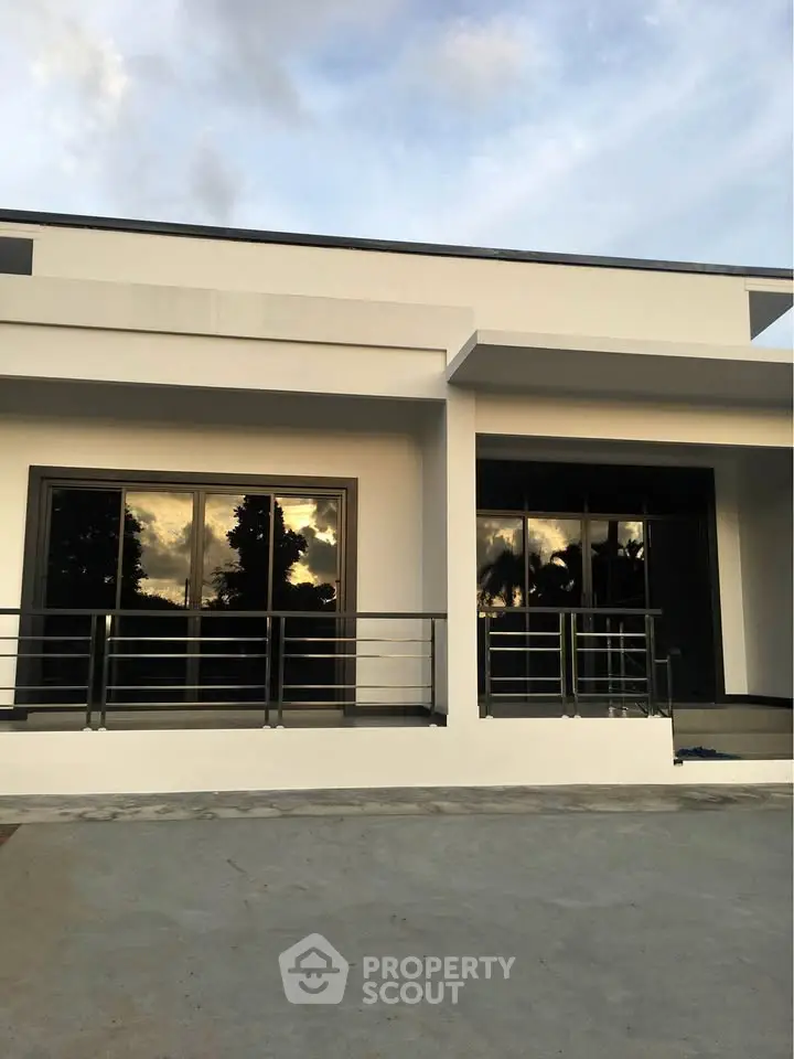 Modern minimalist house exterior with large windows and sleek design.