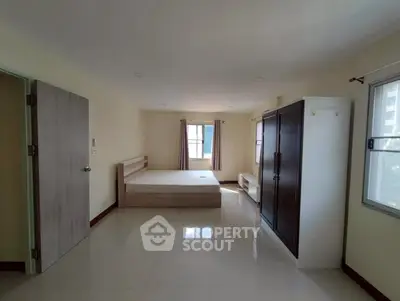 Spacious bedroom with natural light and modern furnishings