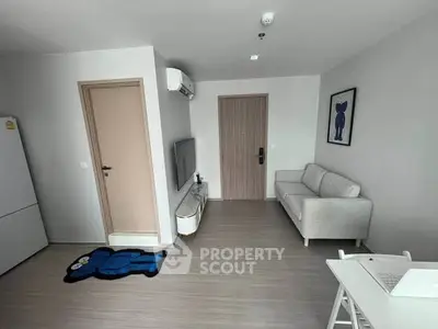 Modern living room with minimalist decor, featuring a cozy sofa, wall-mounted TV, and stylish flooring.
