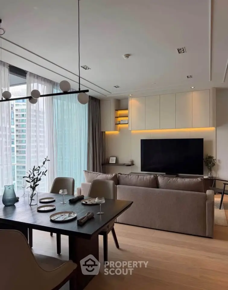 Modern living room with elegant dining area and large TV, featuring floor-to-ceiling windows and stylish decor.