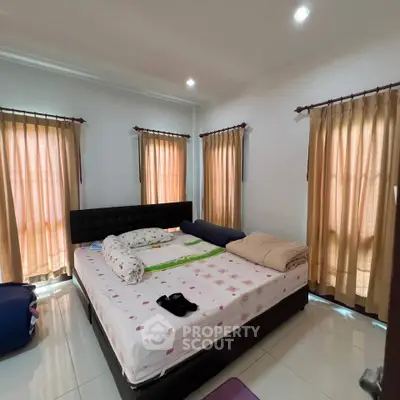 Spacious bedroom with large windows and cozy bed, perfect for relaxation.