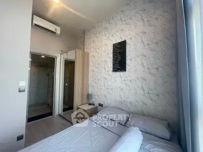 Modern bedroom with stylish decor and ensuite bathroom in a contemporary apartment.