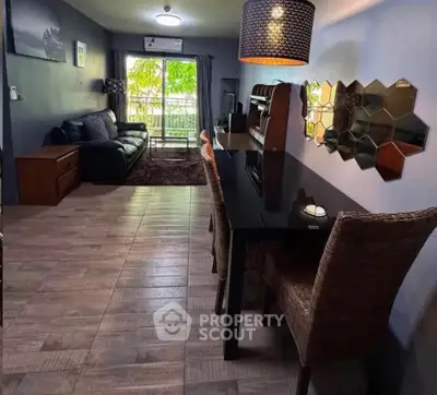 Stylish living room with modern decor and large window offering lush garden views.