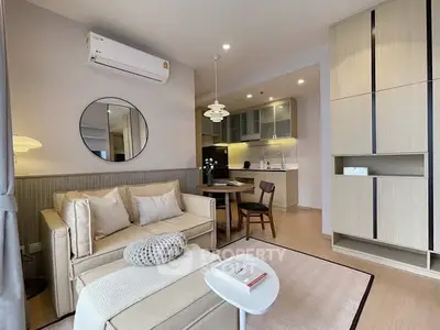 Modern living room with open kitchen, stylish furniture, and elegant lighting in a cozy apartment.