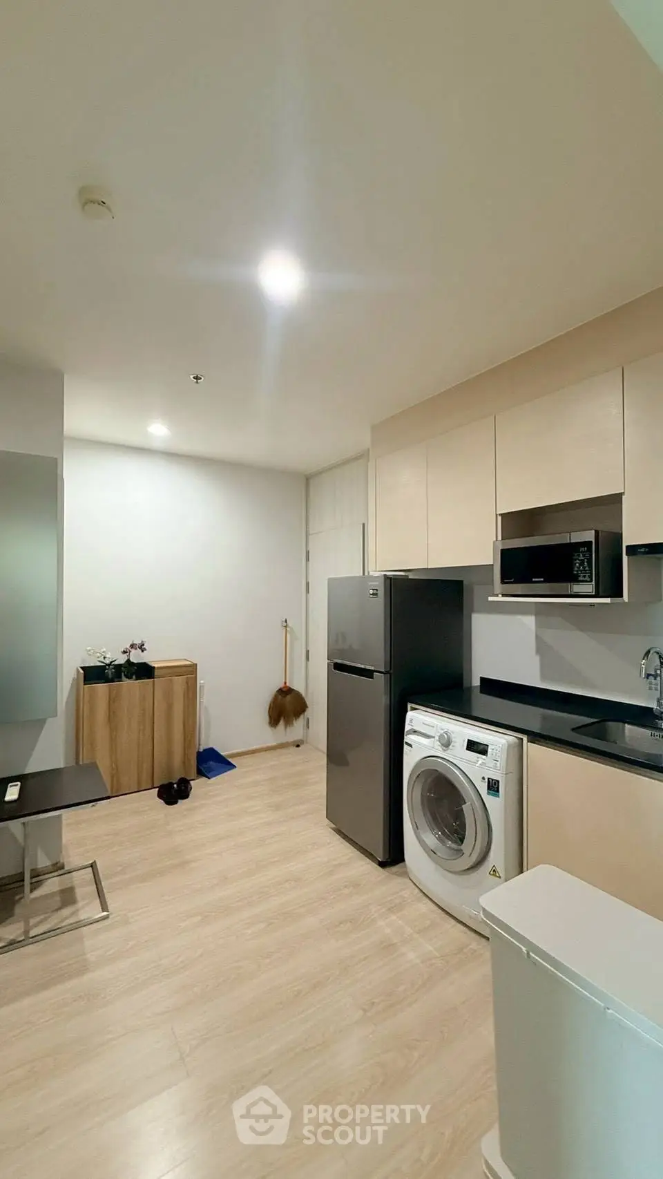 Modern kitchen with washing machine and sleek appliances in a stylish apartment.