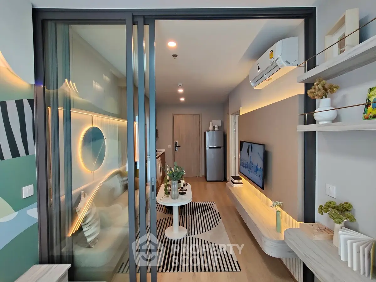 Modern living room with stylish decor and open layout, featuring a wall-mounted TV and sleek furniture.