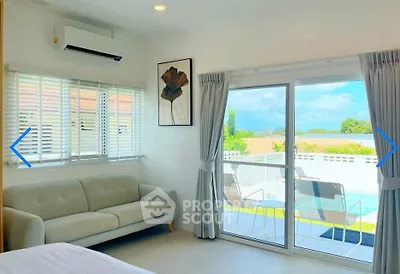Bright living room with pool view, modern sofa, and large sliding glass doors leading to balcony.