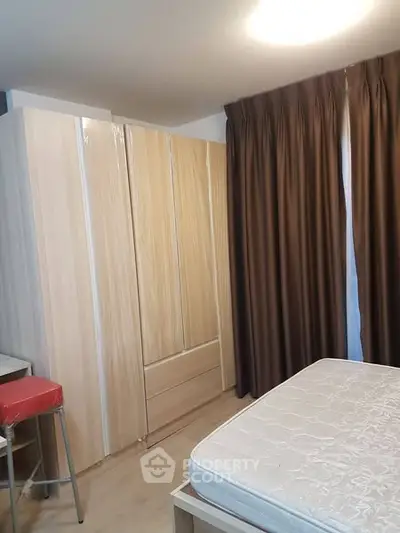Cozy bedroom with large wardrobe and natural light from window