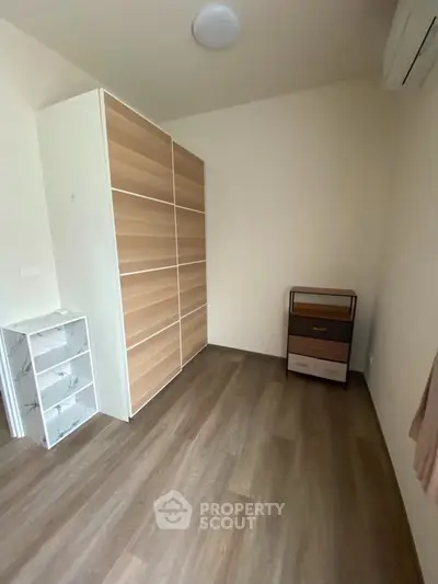 Spacious empty room with wooden flooring and modern wardrobe, perfect for customization.