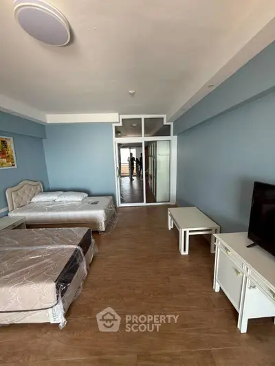 Spacious bedroom with modern furnishings and large window offering natural light.