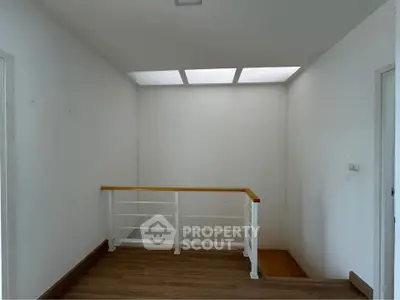 Bright and airy hallway with wooden flooring and modern railing design