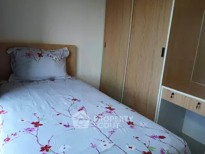 Cozy bedroom with floral bedding and built-in wooden wardrobe