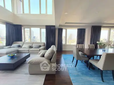 Luxurious open-plan living and dining area with stunning city views and modern furnishings.