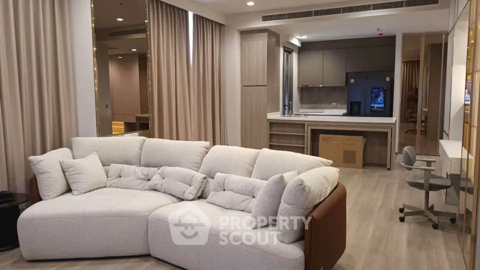 Spacious modern living room with cozy sofa and open kitchen layout