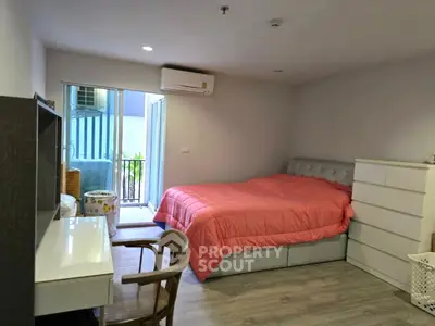 Cozy bedroom with pink bedding and balcony access in modern apartment