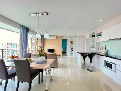 Spacious modern living room with open kitchen and elegant dining area, featuring sleek furniture and bright natural light.