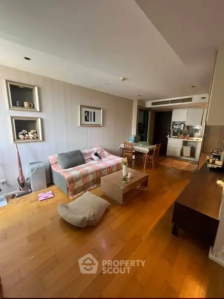 Spacious living room with cozy seating and open kitchen layout in modern apartment.