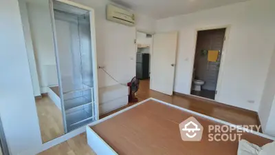 Modern bedroom with wooden flooring and air conditioning in a contemporary apartment.