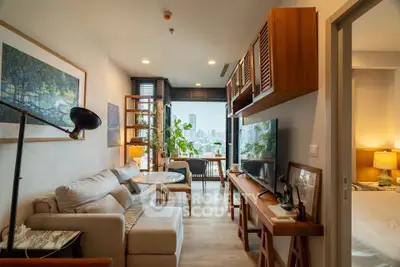 Modern living room with city view, cozy seating, and stylish decor in a high-rise apartment.