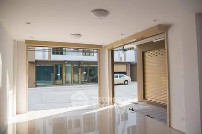Spacious open-plan interior with large windows and glossy floors, ideal for versatile living or commercial use.