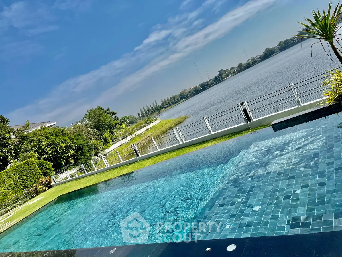 Luxurious waterfront property with stunning pool and serene lake view, perfect for relaxation and leisure.