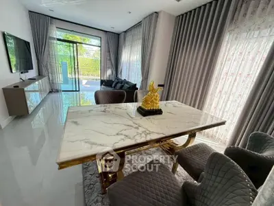 Luxurious living room with marble dining table and elegant decor, featuring large windows and stylish curtains.