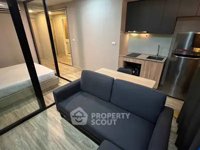 Modern compact apartment with cozy living area and sleek kitchen design.