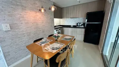 Modern kitchen with dining area, featuring sleek cabinetry and stylish lighting.