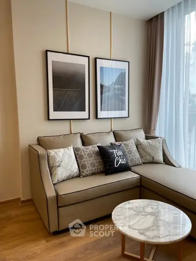Stylish living room with elegant sofa, chic decor, and natural light from large windows.