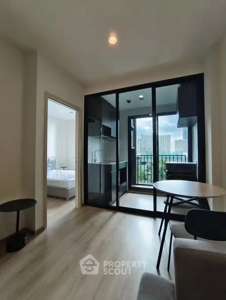 Modern apartment with open layout and city view balcony, featuring sleek interiors and natural light.