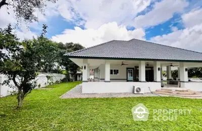 Charming single-story home with spacious green lawn and modern roof design.