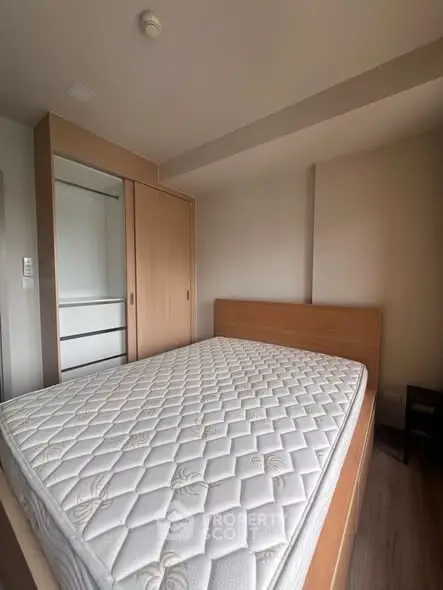 Spacious bedroom with wooden wardrobe and comfortable mattress in modern apartment.