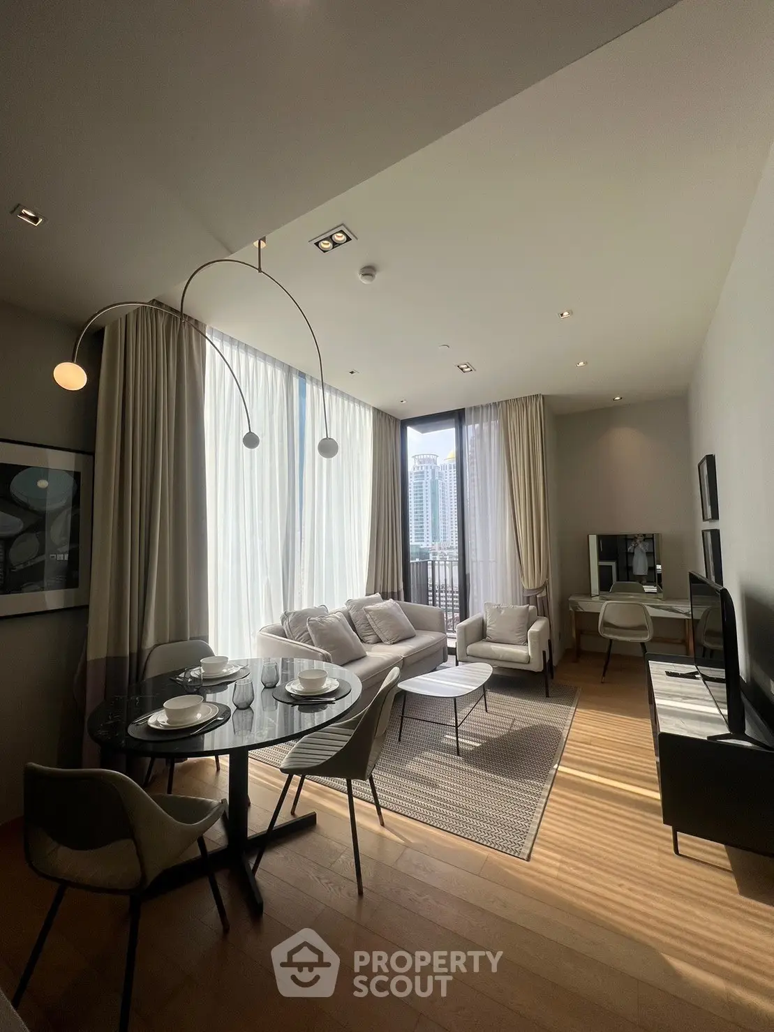 Modern living room with elegant decor and city view, featuring stylish furniture and natural light.