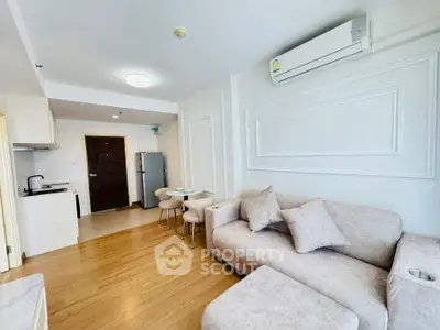 Modern living room with cozy sofa and open kitchen layout in bright apartment.