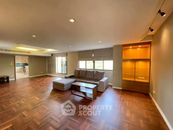 Spacious living room with elegant wood flooring and modern furniture.
