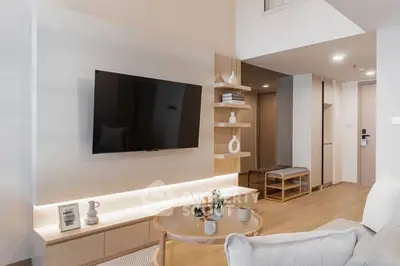 Modern living room with sleek TV setup and stylish decor in a contemporary apartment.