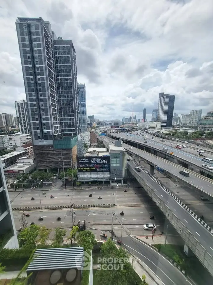 Stunning cityscape view from high-rise building with modern architecture and bustling highway below.