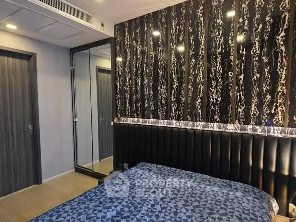 Modern bedroom with stylish wallpaper and mirrored closet doors