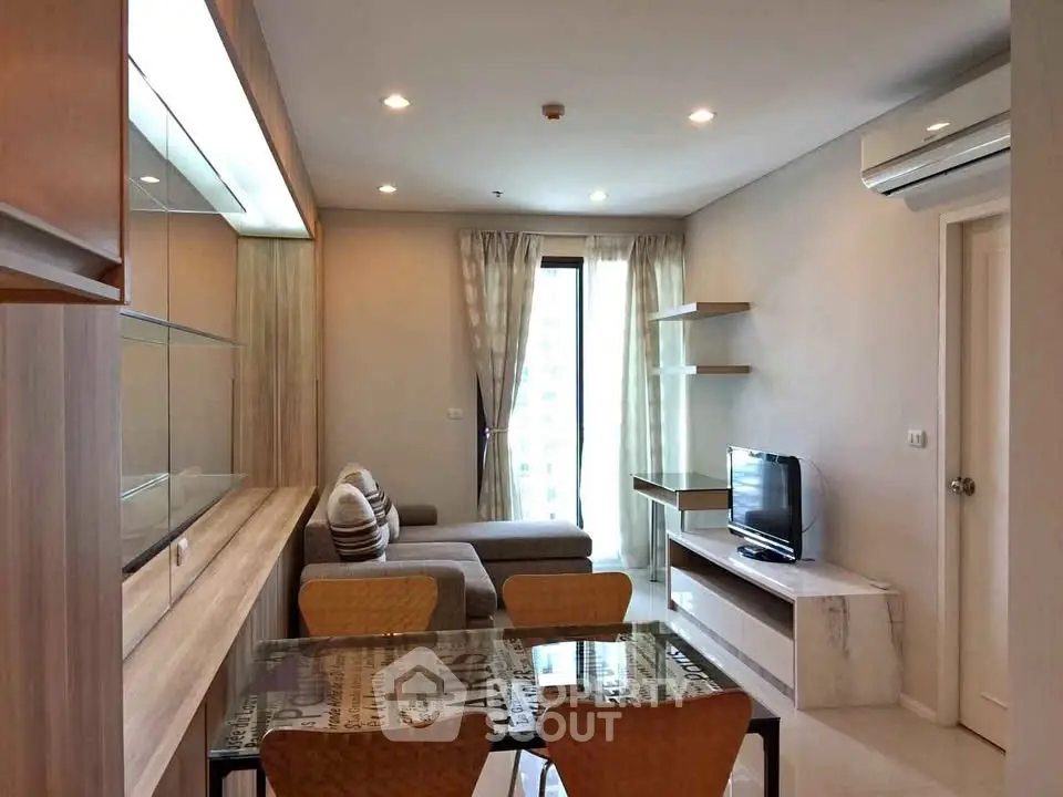 Modern living room with stylish furniture and natural light in a high-rise apartment.
